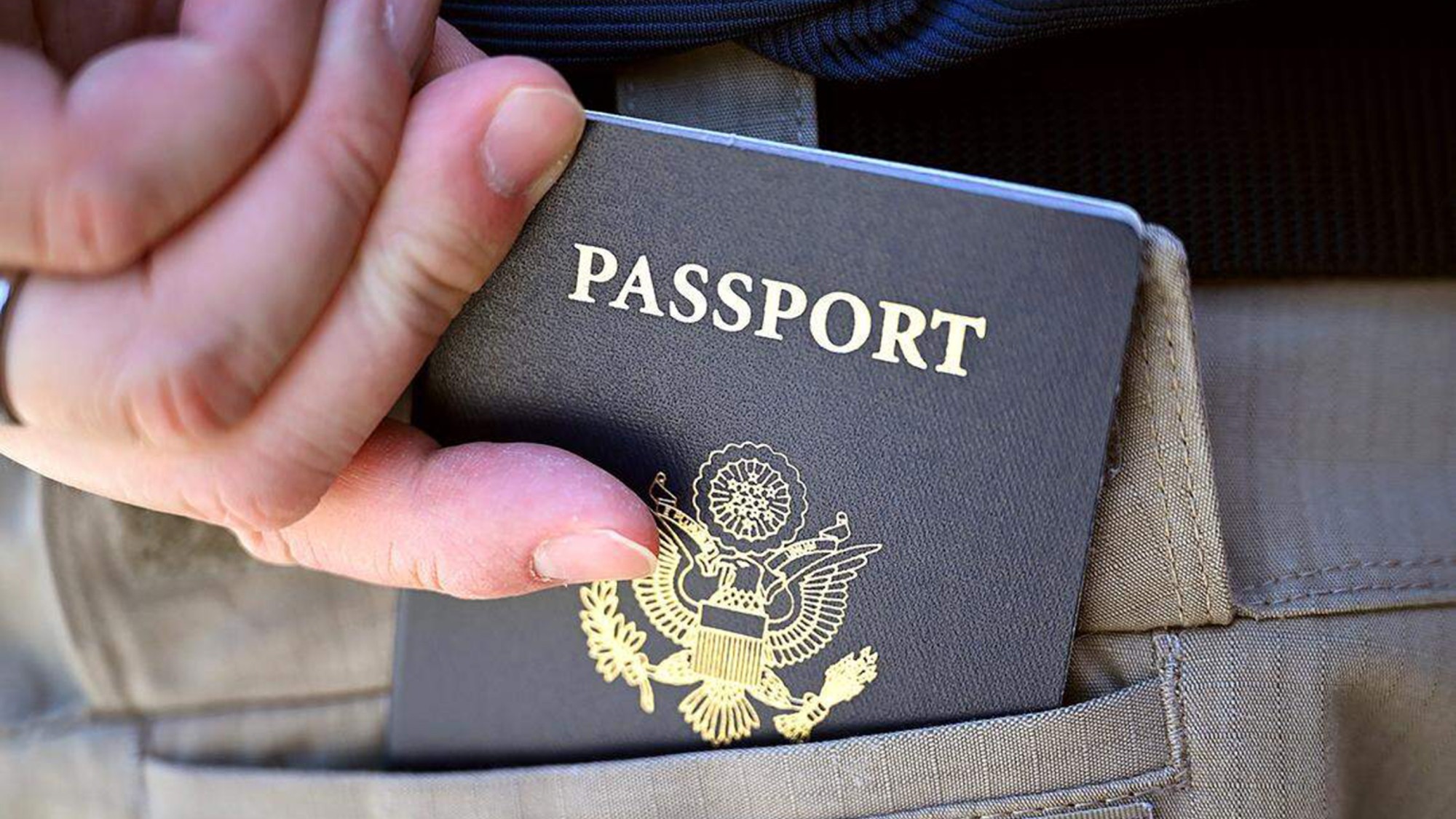 A man places his U.S. passport into his back pocket in Fresno, California.