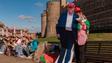 A woman stands with a cutout of President Donald Trump outside the U.K.&rsquo;s Windsor Castle 